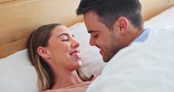 Kiss, love and happy with couple in bedroom for relax, connection and support in the morning. Care, wake up and commitment with man and woman in bed at home for partner, marriage and smile together. - Footage, Video
