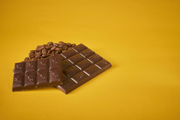 шоколад и орехи на желтом фоне - Фото, изображение