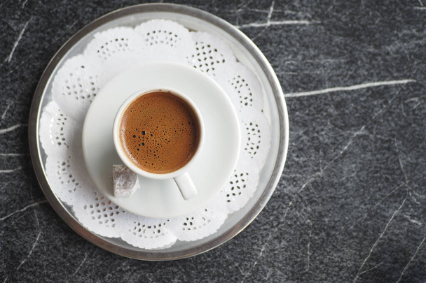 una taza de café turco sobre fondo de baldosas negras , - Foto, Imagen