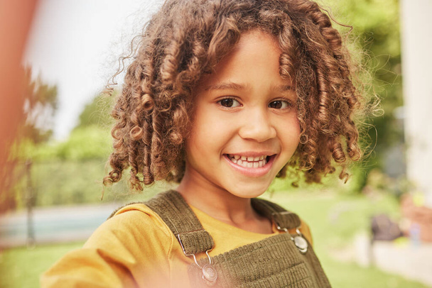 Selfie, feliz y retrato de un niño en un parque jugando en unas vacaciones de verano, vacaciones o aventura. Felicidad, sonrisa natural y cara de niño colombiano tomando foto en jardín verde en la naturaleza. - Foto, imagen