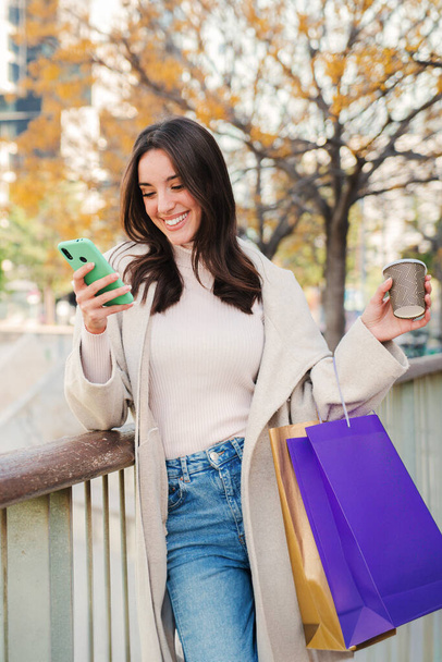 Függőleges portré egy fiatal nőről, aki mobilt használ, üzenetet küld. hölgy nézi startphone, tartalom megosztása a közösségi média app. Tini lány egy mobiltelefon készülék vásárlás után - Fotó, kép