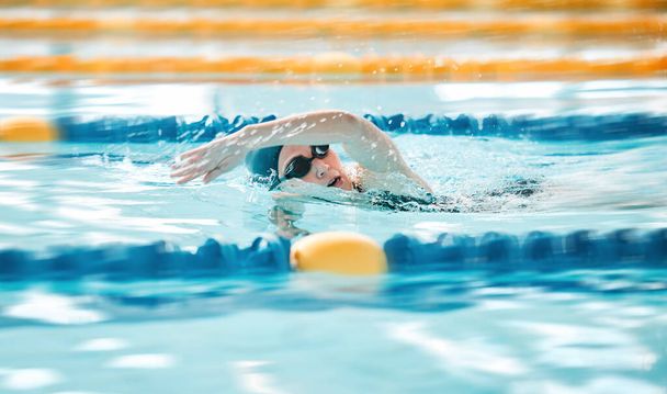 Woman, pool and swimming in sports fitness, exercise or training in water splash or athletics. Female person, athlete or professional swimmer in competition, race or marathon in workout practice. - Photo, Image