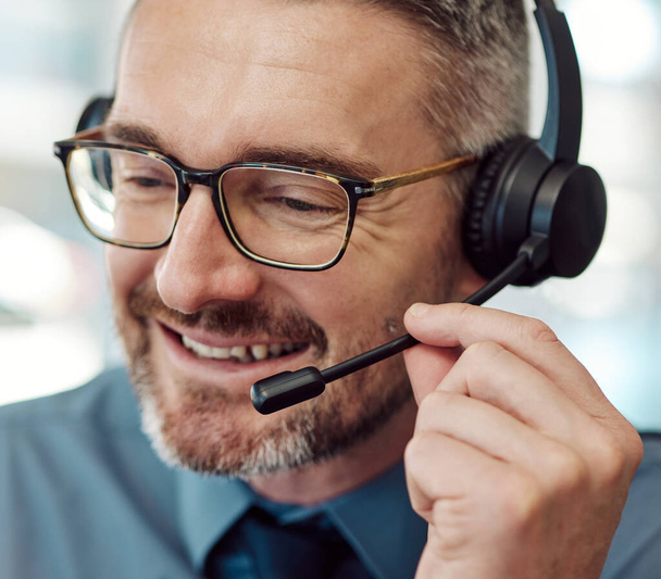 Happy man, face and call center with headphones in customer service, support or telemarketing at office. Closeup of mature businessman or consultant agent smile in online advice, help or contact us. - Photo, Image