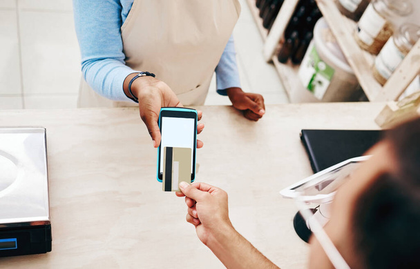 Credit card, store payment and above hand with cashier, machine and transaction in a retail shop. People, ecommerce and shopping with electronic pay, fintech and customer with purchase and tech. - Photo, Image