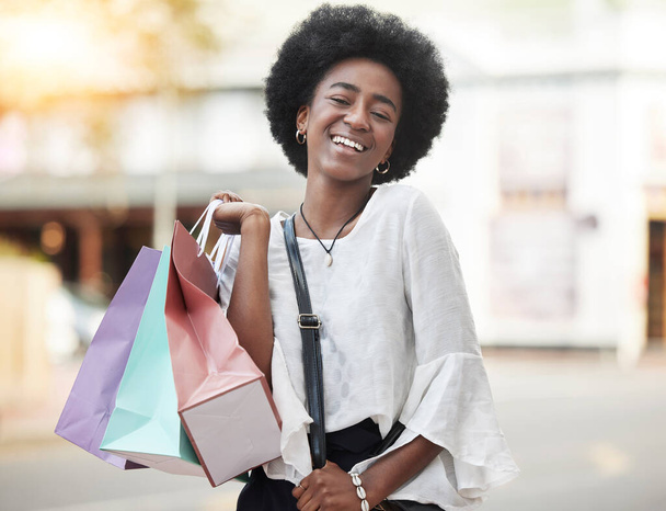 Mujer negra, bolsa de compras y retrato de un cliente feliz al aire libre en una ciudad para el comercio al por menor, venta o promoción. Persona africana con una sonrisa y emocionada por comprar productos de moda en viajes urbanos. - Foto, Imagen