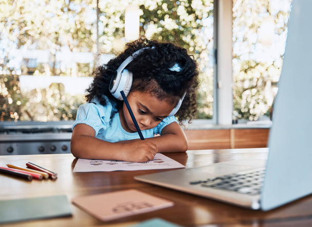 Online-Lernen, Kopfhörer und Kinderschreibtest am Schreibtisch für kreative Bildung und Entwicklung. Audio-Technik, Studium und Kind mit Laptop für Grundschulbildung, virtuelle Hilfe und Leseförderung zu Hause. - Foto, Bild