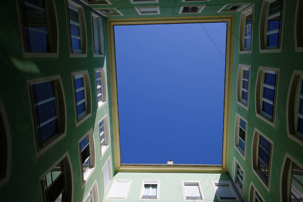 Κάτω ευρεία γωνία άποψη της ιστορικής εσωτερικής αυλής με όμορφη πρόσοψη κτιρίου με μπλε ουρανό. Ατζάτσιο. Κορσική, Γαλλία. - Φωτογραφία, εικόνα