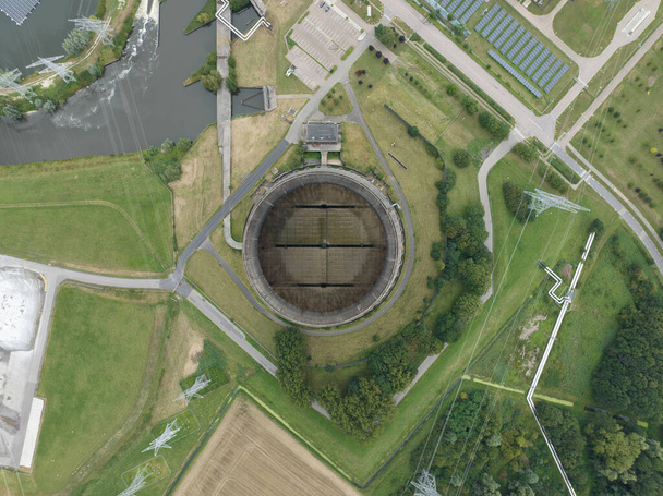 Uma visão aérea de cima para baixo de uma torre de refrigeração industrial a partir de uma grande instalação de geração de energia. - Foto, Imagem