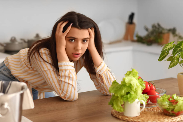 Giovane donna che ha un attacco di panico in cucina - Foto, immagini