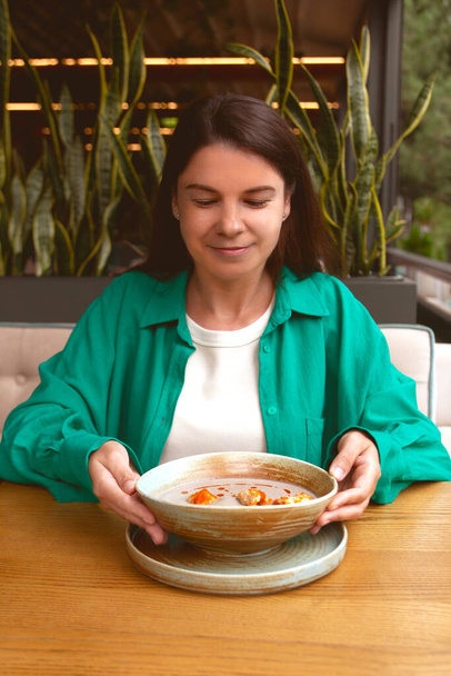 la donna gode di mangiare la minestra per pranzo in caffè verde vegetariano - la minestra alla panna di fungo con cracker. cibo sano - Foto, immagini