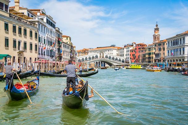 Venetië, Italië - 30 mei 2023: Traditionele gondelrit over het Canal Grande bij de Rialtobrug (Ponte di Rialto). Toeristen in Venetië. - Foto, afbeelding