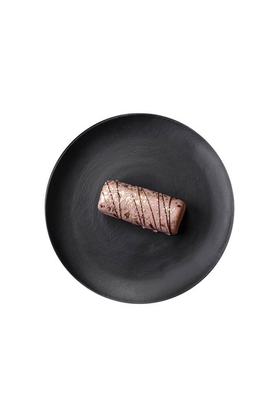 Delicioso queijo doce com xarope coberto com chocolate e nozes em uma placa de cerâmica em um fundo de concreto escuro - Foto, Imagem