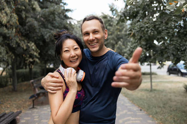 heureux asiatique couple prendre selfie avec smartphone dans parc pendant matin séance d'entraînement - Photo, image