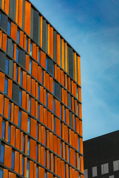 Перспектива фасада современного корпоративного здания с красочными отражениями в окнах - Фото, изображение