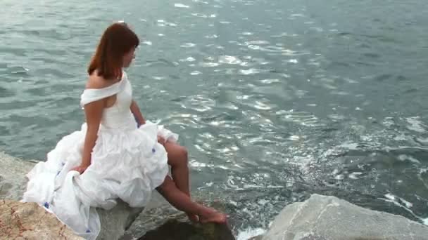 Csinos, fiatal nő a fehér ruha a Rock-tenger - Felvétel, videó