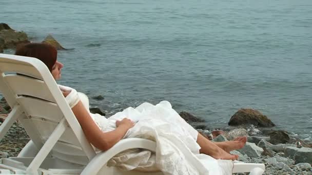 Jeune femme en robe blanche allongée sur Chaise-Longue
 - Séquence, vidéo