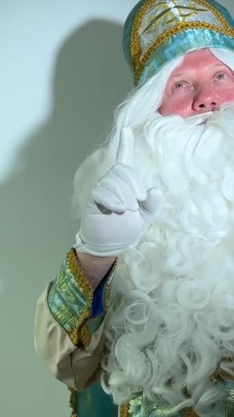 Aziz Niklas ellerini sallayarak sihirli bir Noel Baba yaratıyor ve evde yeni yılı kutluyor. Noel arifesinde, Noel Baba dans ediyor. Aile tatili kavramı. - Video, Çekim