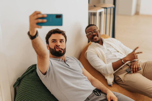 Diversos compañeros de trabajo cansados tomando una selfie mientras descansan del trabajo - Foto, imagen
