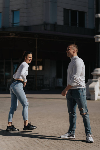 Όμορφο ζευγάρι γελάει και διασκεδάζει ενώ στέκεται στο κέντρο της πόλης - Φωτογραφία, εικόνα