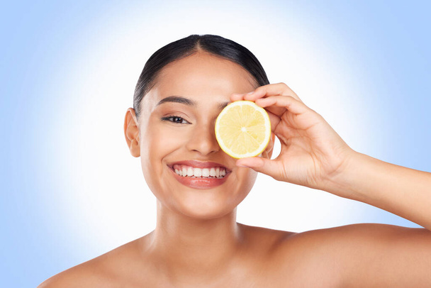 スキンケア, スタジオの肖像画と有機デトックス治療のためのレモンを持つ幸せな女性, 自然なセルフケアルーチンやフェイシャルクリーニング. ビタミンCの利点, ブルーバックグラウンドの人間の果物と顔の笑顔. - 写真・画像
