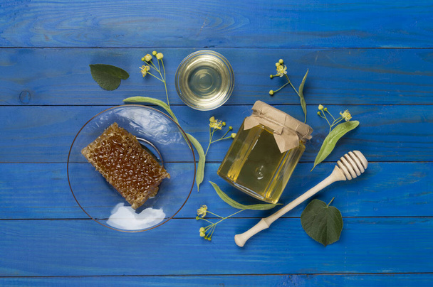 Linden honey with leaves and flowers on wooden backgroung, top view - Photo, Image