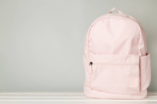 Ροζ σχολική τσάντα σε τραπέζι από μπετόν - Φωτογραφία, εικόνα