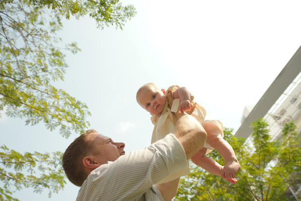 Hombre lanzando a su hijo
 - Foto, Imagen