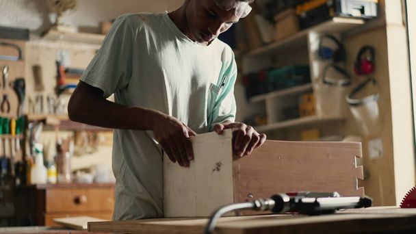 Muebles negros jóvenes de la fabricación del carpintero en taller de carpintería usando el equipo de perforación - Foto, Imagen