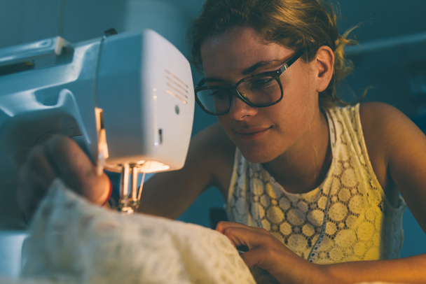 Young dressmaker sewing - Foto, afbeelding