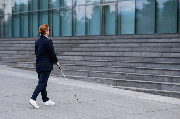 Blind businesswoman walking with tactile cane to business center - Фото, изображение