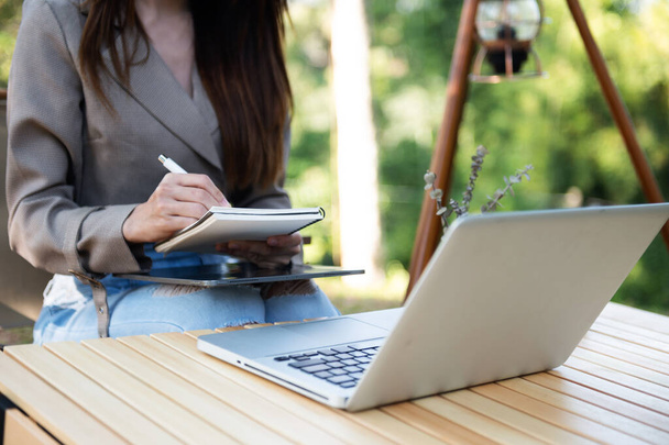 Businesswoman using digital tablet and laptop. Closeup on blurred background - Foto, Imagem