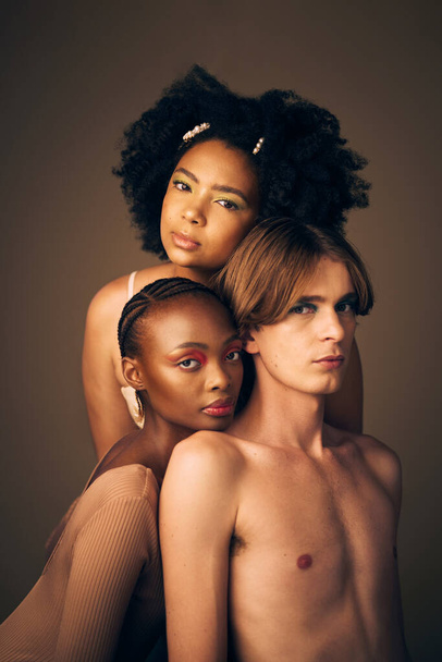 Makeup, glow and portrait of models in studio with creative, cosmetic and facial art for beauty. Queer, diversity and gen z man and women with face inclusion or skincare isolated by brown background - Foto, Bild