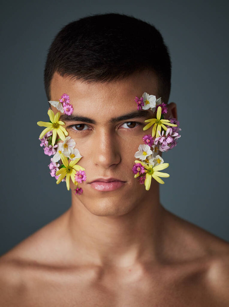 Face, man and flowers, beauty and natural, cosmetics and headshot with art deco isolated on studio background. Nature aesthetic, portrait and dermatology, eco friendly skincare and clean with spring. - 写真・画像