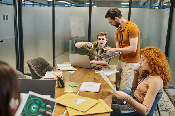 menedzser mutató laptop közel csapat vezetője és munkatársai tárgyaló, startup, ötletbörze - Fotó, kép