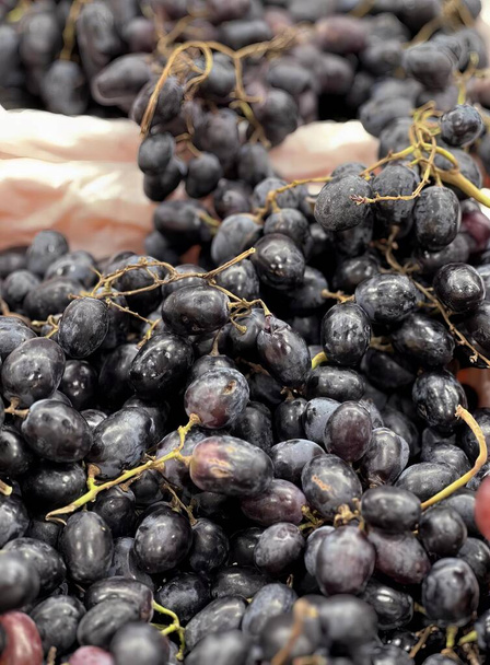 photographie d'un bouquet de raisins assis sur une table, exposition d'épicerie de raisins et d'autres fruits à vendre. - Photo, image