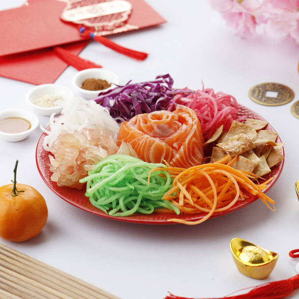 Yusheng, Yee Sang nebo Yuu Sahng se obvykle skládá z proužků syrové lososové ryby, smíšené strouhaná zelenina, omáčky a koření - Fotografie, Obrázek