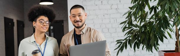 щасливий афроамериканський бізнесмен і азіатський чоловік з ноутбуком, різноманітні офісні працівники, банер - Фото, зображення