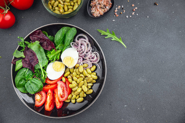 edamame bean salad vegetables, tomato, boiled egg, salad dressing ready to eat healthy appetizer meal food snack on the table copy space food background rustic top view keto or paleo diet vegetarian vegan food no met - Photo, Image