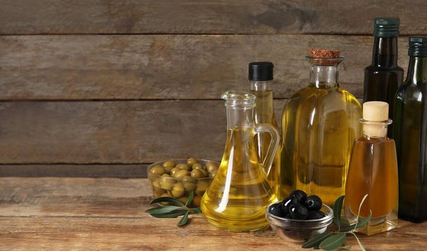Zdrowa oliwa z oliwek na drewnianym tle z miejscem na tekst - Zdjęcie, obraz