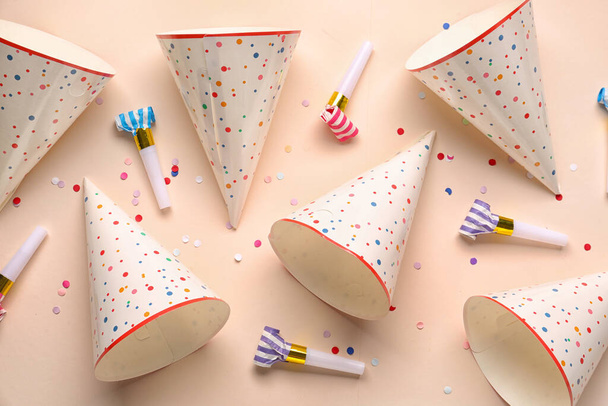 Party hats and whistles on pale orange background - Photo, Image