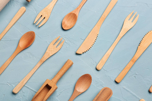 Messer, Gabeln und Löffel aus Holz auf blauem Hintergrund - Foto, Bild