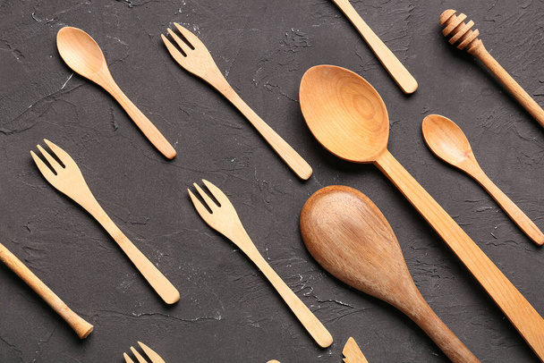 Trempette, cuillères et fourchettes en bois sur fond noir - Photo, image