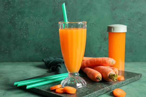 Vidro e esportes garrafa de suco de cenoura fresca no fundo verde - Foto, Imagem