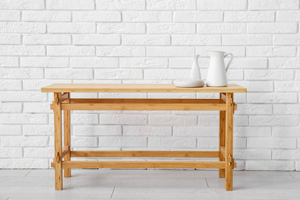 Dřevěný konferenční stolek s výzdobou u zdi z bílých cihel - Fotografie, Obrázek