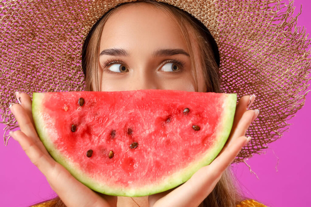 Young woman with fresh watermelon on purple background, closeup - Photo, Image