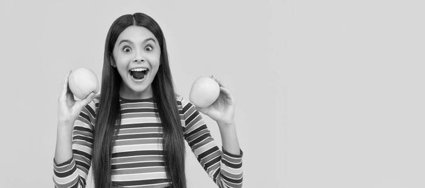 興奮した女の子の子供は健康な歯の黄色の背景のためのリンゴを保持します。リンゴと子供の女の子の肖像画、水平ポスター。コピースペース付きバナーヘッダー - 写真・画像