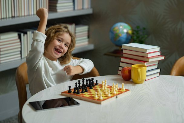 Spannend kind schaken. Hij speelt bordspel. Denkend aan kinderbrainstormen en idee in schaakspel. Schaakschool en -onderwijs - Foto, afbeelding