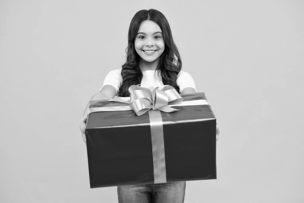 Happy teenager, positive and smiling emotions of teen girl. Child with gift present box on isolated studio background. Gifting for kids birthday - Foto, Imagem