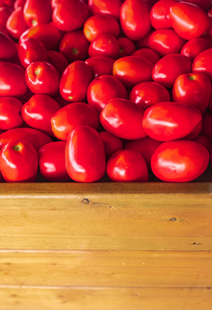Frische reife Gartentomaten mit Holzkiste für Kopierraum. Rote Tomaten auf einem lokalen Markt. Nahaufnahme, niemand - Foto, Bild