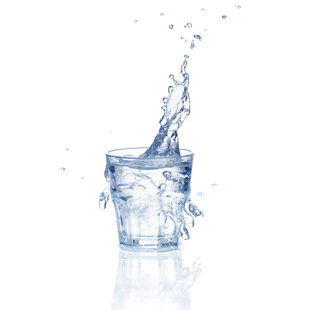 Zoet water splash in een glas geïsoleerd op witte achtergrond - Foto, afbeelding
